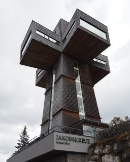Mit dunklen Holzschindeln verkleidetes Jakobskreuz aus
                           der Untersicht.