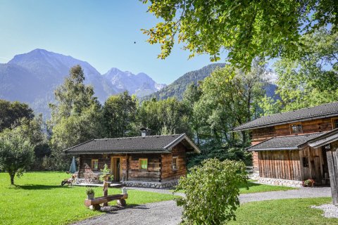 Urige Hütten im Grün vor Bergpanorama
