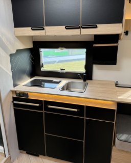 Küchenzeile des Chausson Titanium 640 mit
                           Spüle, abgedecktem Kochfeld, Arbeitsfläche, Oberschränken und mehreren Schubladen.