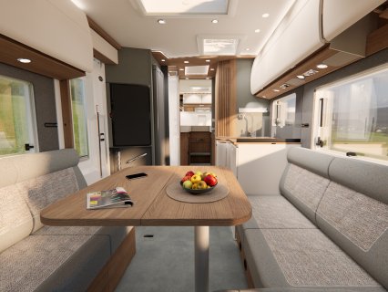 Wohnmobil-Innenraum mit zwei gegenüberliegenden Sitzbänken, Esstisch und Küchenzeile im Hintergrund.