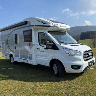Chausson Titanium 640 von schräg
                           vorne auf der Einstiegsseite mit Aufbautür, Seitenfenstern, Außenklappen und eingefahrener Markise.