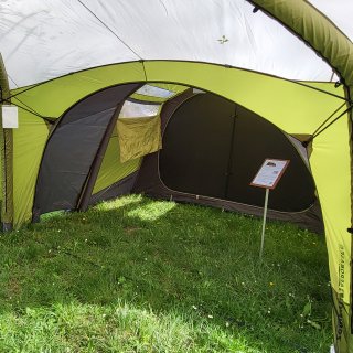 Auf dem Bild ist der Eingang vom
                           Zelt Aerobase von Zempire auf einer Wiese stehend abfotografiert.
