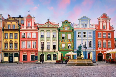 bunte Häuser
                           in der Altstadt von Posen, zwei rote, zwei grüne und je ein blaues und ein gelbes Haus, viele Verzierungen an den Fassaden,
                           Brunnen mit einer Statue in der Mitte im rechten Bildrand.
