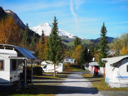 Im Bild sieht man im Vordergrund die Stellplätze des Campingplatzes Fieberbrunn, sowie im Hintergrund
                           die Aussicht mit Berglandschaft