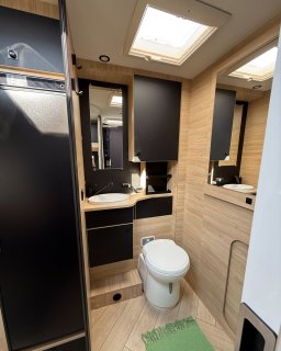 Bad im Heck des Chausson Titanium 640 mit
                           Toilette, Waschbecken, Spiegeln, Ablagen und Dachfenster.