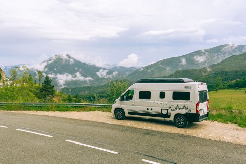 Auto von seitlich links hinten neben Straße fotografiert, im Hintergrund die
                           Wälder und das Gebrige der Verdon-Schlucht. 