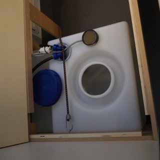 Leerer und offener Frischwassertank im Inneren eines Wohnwagens.