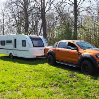 Der Wohnwagen Adria Adora 593 UP und ein Ford Ranger als Zugfahrzeug von vorne rechts abfotografiert.