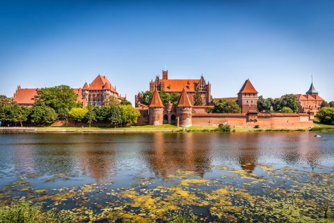 Blick auf die Marienburg, dem größten Backsteingebäude
                           der Welt, im Vordergrund der Fluss Nogat,