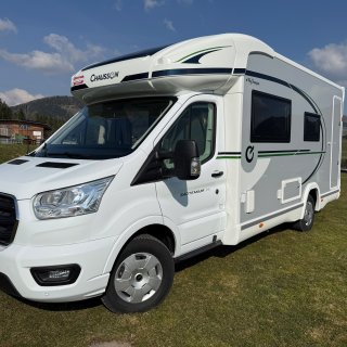 Weiß-grauer
                           Chausson Titanium 640 von schräg vorne mit erhöhtem Aufbau, seitlichen Fenstern und grüner sowie schwarzer Dekorlinie.
