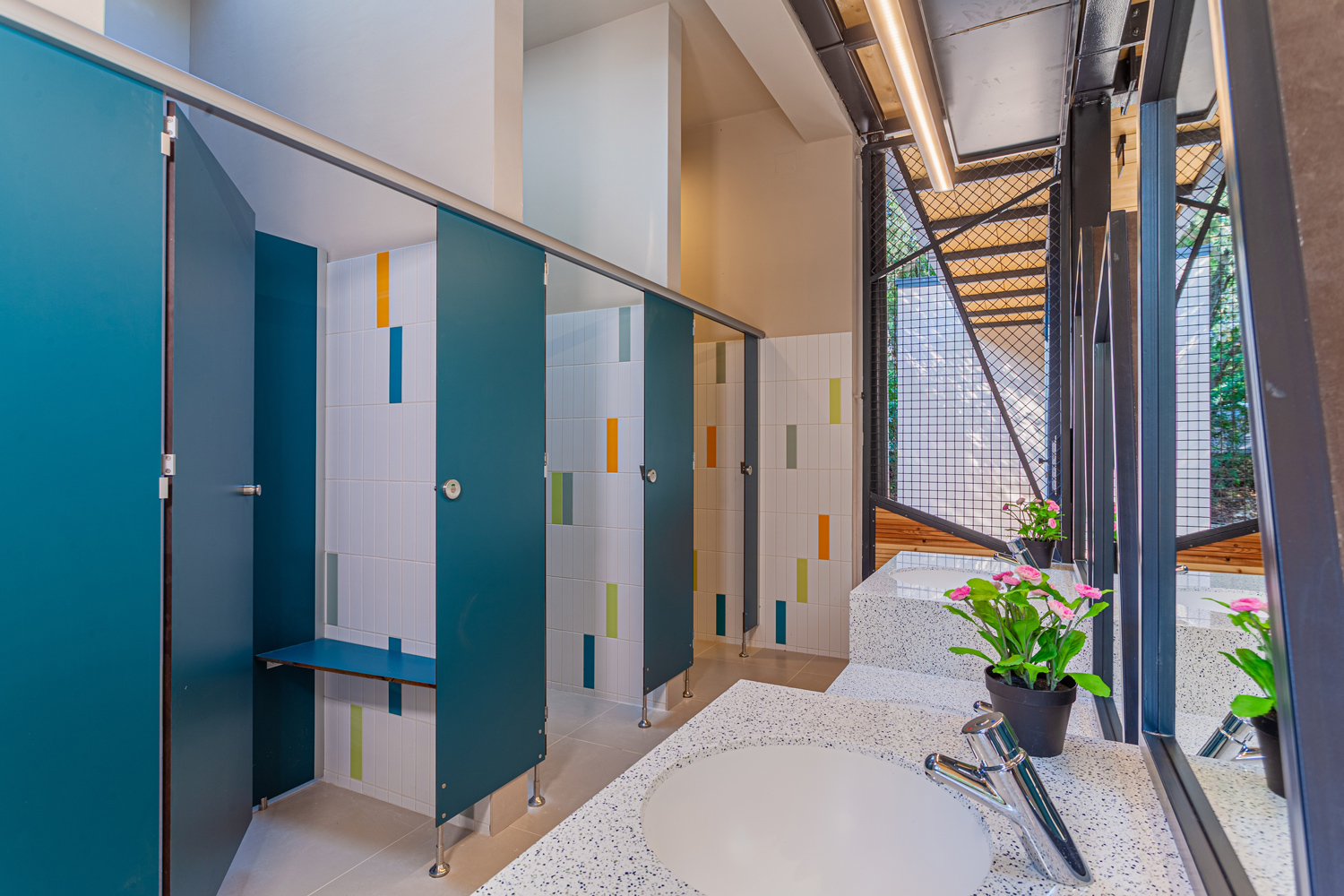 moderene, bunte und lichtdurchflutete Toilettanlage mit Holzkonstruktion
                                 und Pflanzen 