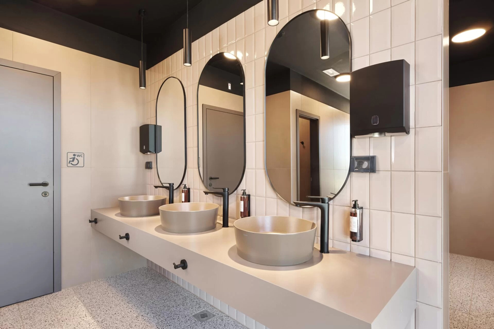 Auf dem Bild
sind Waschbecken der Sanitäranlagen im San Servolo Resort zu sehen, sowie der Eingang zur barrierefreien Toilette.